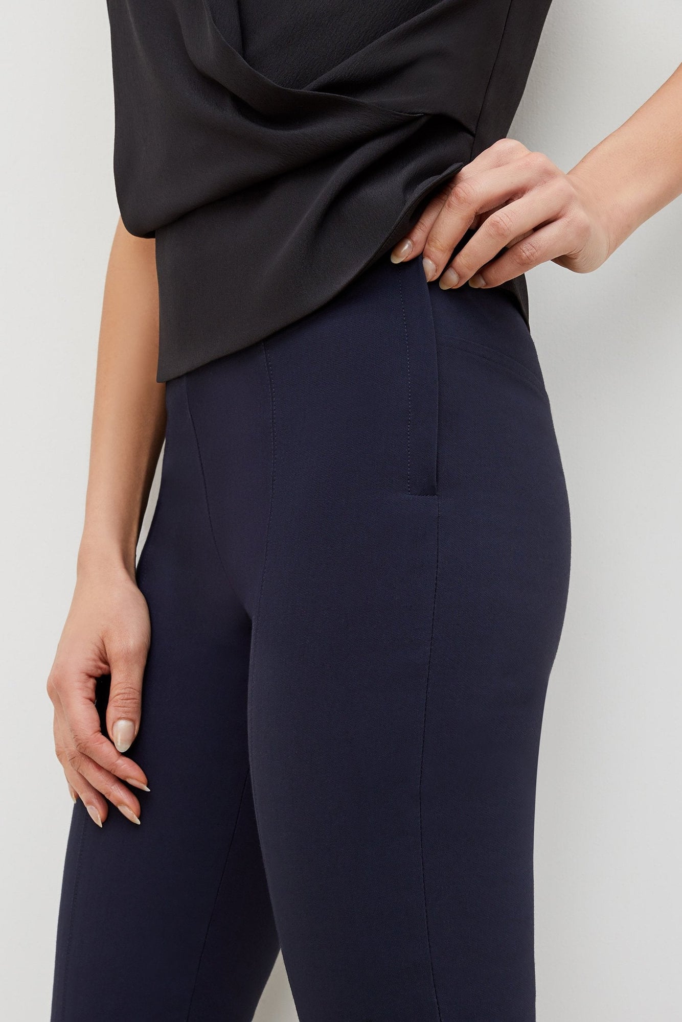 Side image of a woman standing wearing the foster pant in dark navy | Grid Hover | Exclude