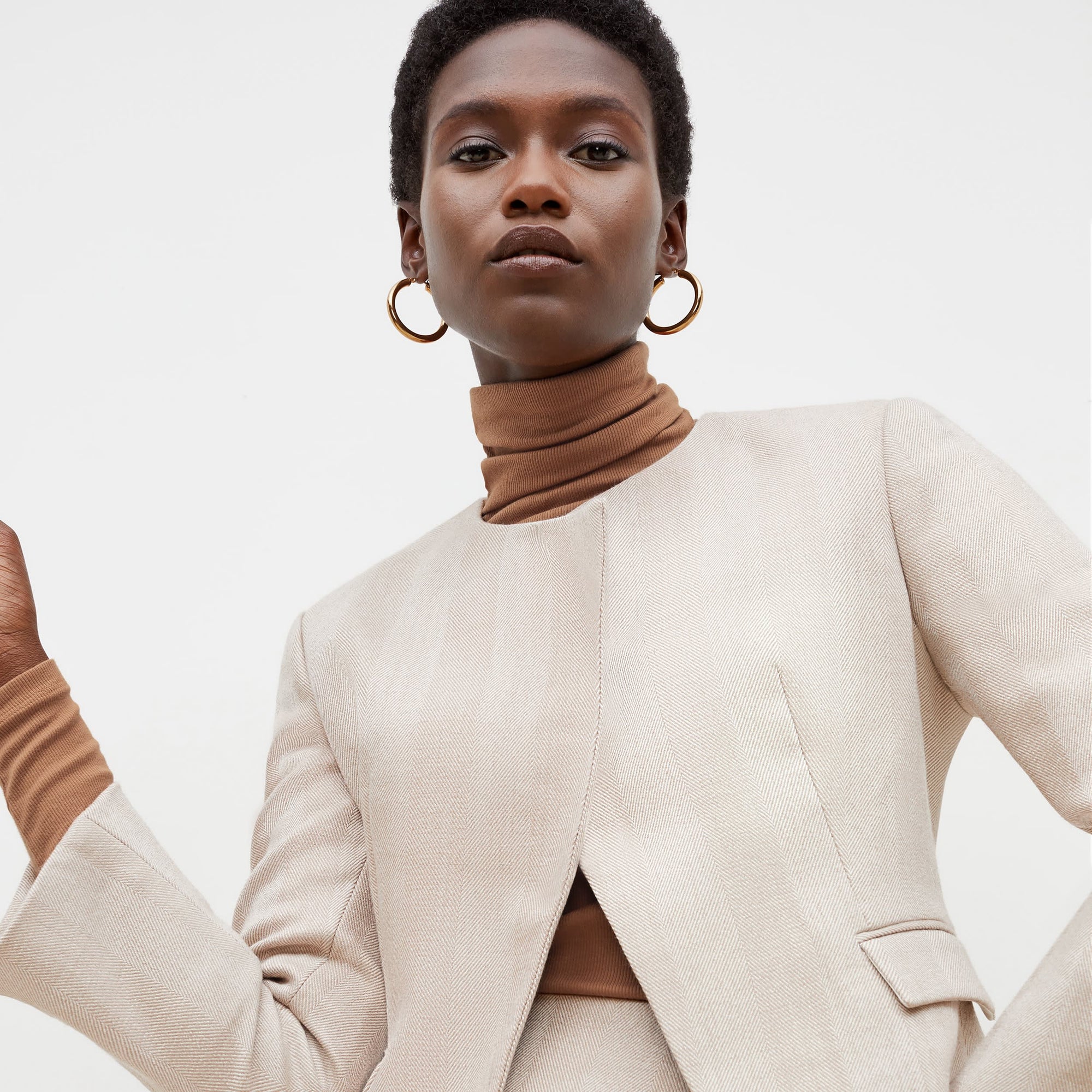 Front image of a woman standing wearing the axam top in camel | Exclude