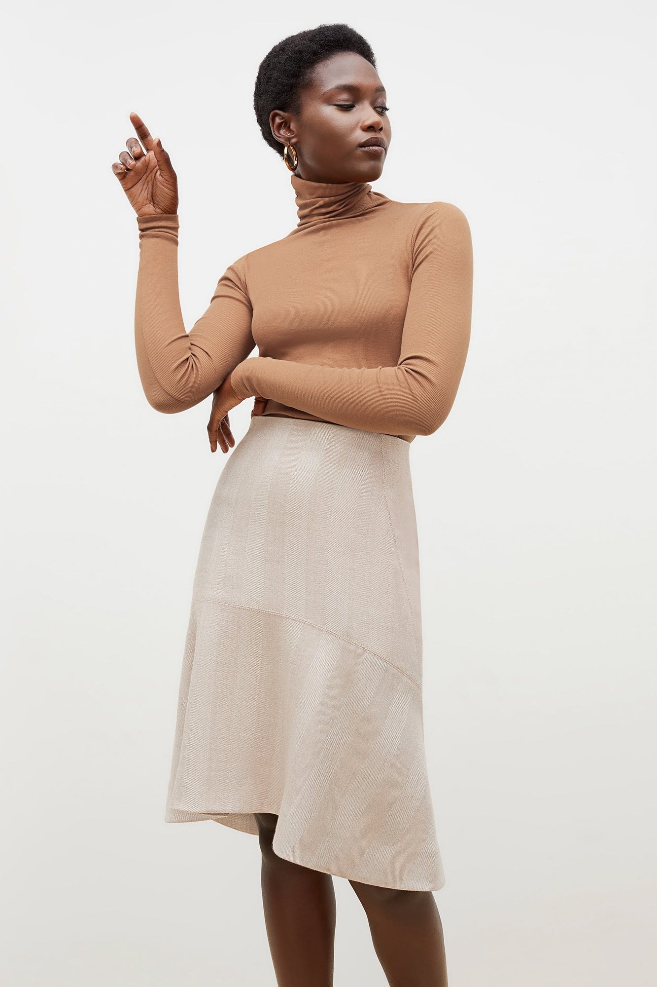 Front image of a woman standing wearing the axam top in camel | Exclude