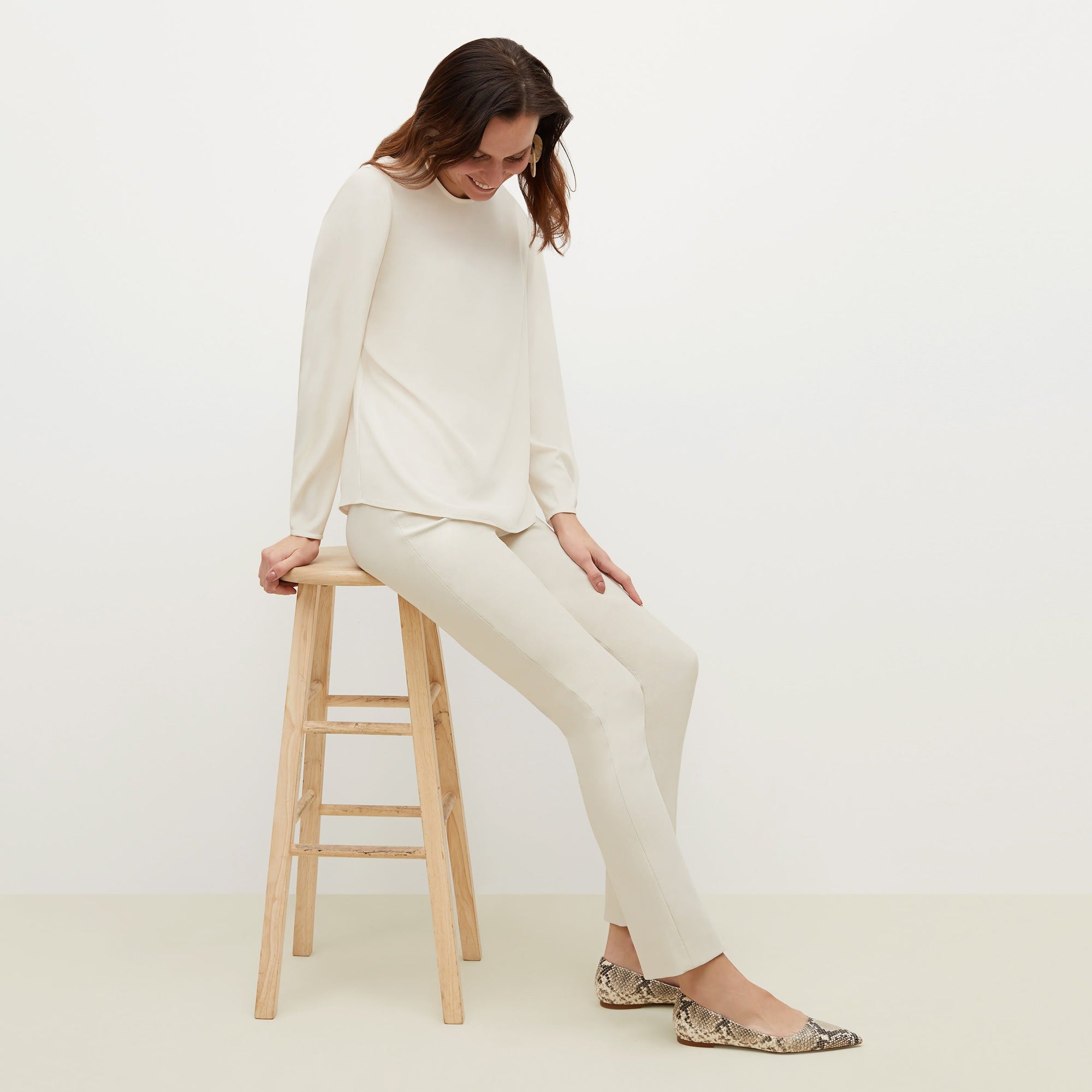 Side image of a woman standing wearing the foster pant in bone | Exclude