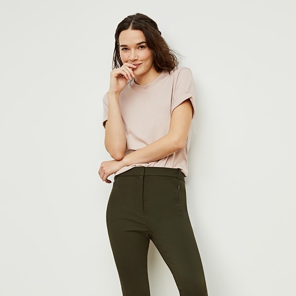 Front image of a woman standing wearing the curie pant in dark olive | Exclude