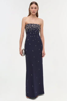 Navy strapless gown with silver beaded embellishments concentrated at bodice, flowing down skirt.