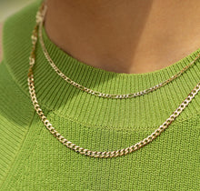 Lifestyle Model. Close up of woman wearing stacked gold chain necklaces