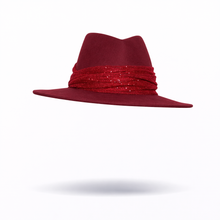 Red fedora hat with decorative sparkly band on a white background