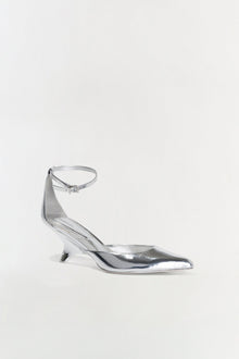 Silver metallic leather wedge pump with pointed toe and ankle strap buckle closure.