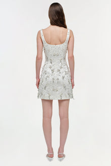 White sleeveless mini dress with all-over beaded embellishment, scoop neckline, and fitted bodice, shown on model from back.