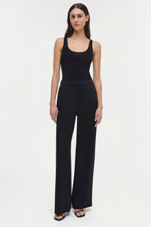 Woman wearing black ribbed tank top and black wide-leg pants with flat front styling.