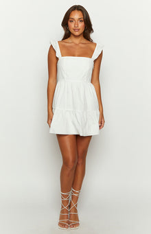 White mini dress with a fitted bodice, square neckline, ruffled cap sleeves, and tiered A-line skirt