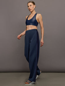 Model wears navy wide leg pants with an elastic waistband. 