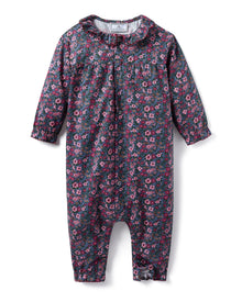 Baby's Twill Madeline Romper in Fleurs de Saison features long sleeves, a dark base with pink and purple floral print, front snap closures, a rounded collar, and gathered cuffs at wrists and ankles.