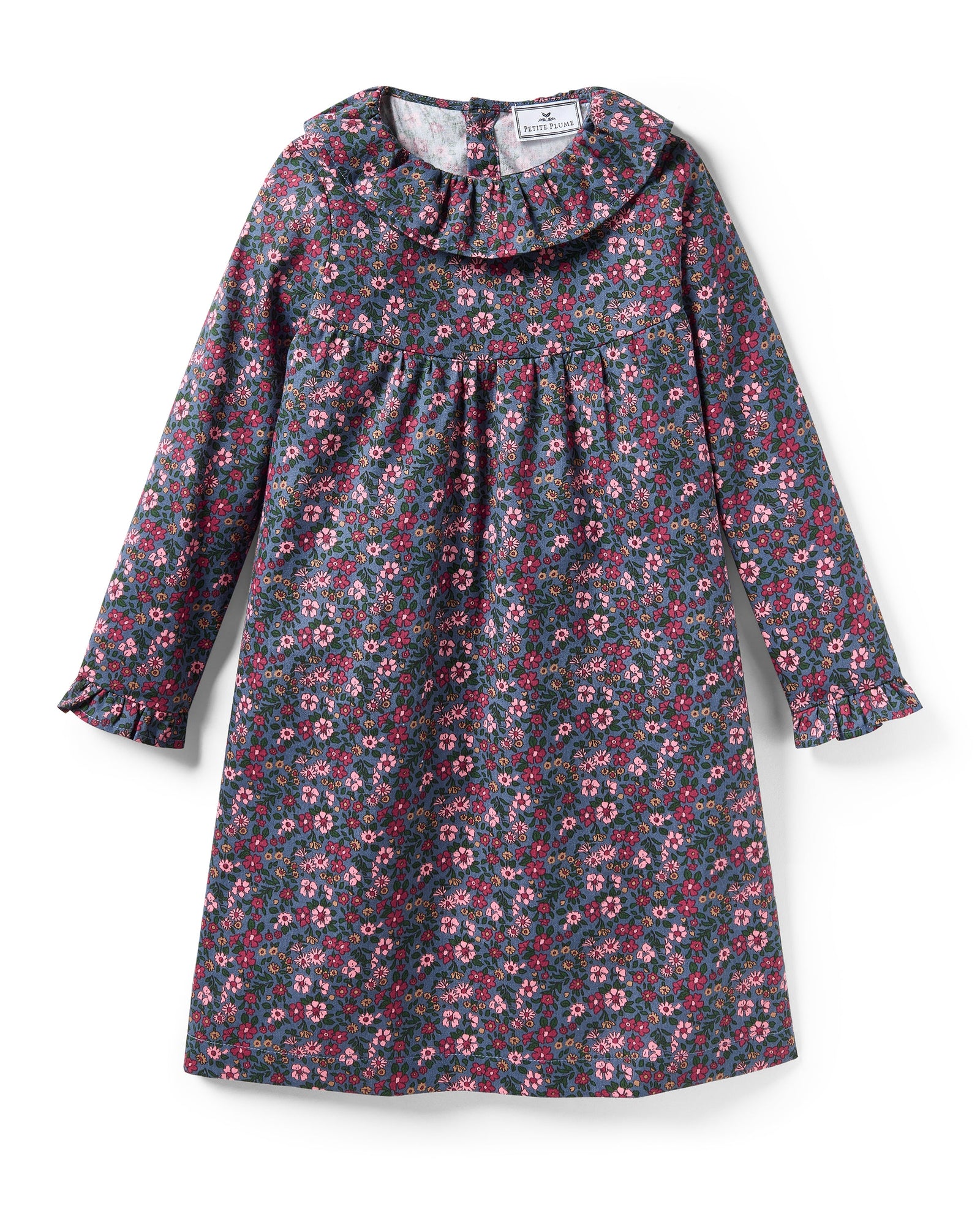 The Girl's Twill Scarlett Nightgown in Fleurs de Saison is a long-sleeved, knee-length dress with a ruffled collar and cuffs, featuring pink and white flowers with green leaves on a dark background.