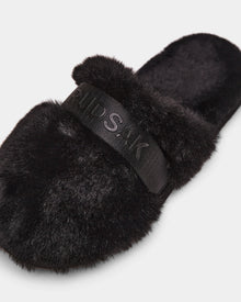 The FLUFF - L223509 Black by Rudsak is a cozy women's slipper with a wide, embossed strap, black faux-fur texture, and open back—perfect lounge footwear for comfort.