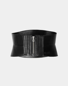 The LEA - 8424519 Black by Rudsak is a women’s wide leather corset belt with a front silver zipper, vertical stitched details, and a stretch back waist for comfort, shown on a plain light gray background.