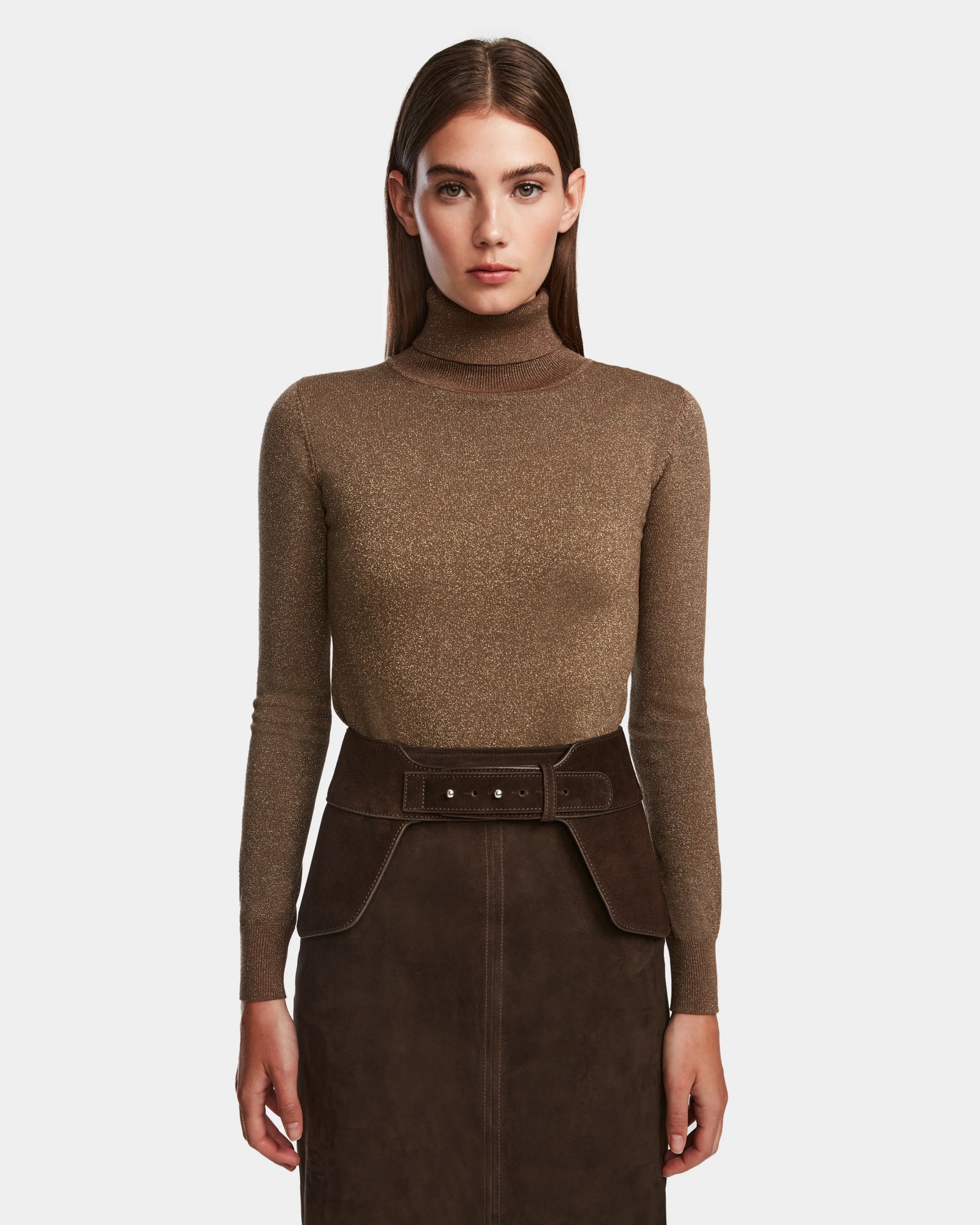 A woman with straight brown hair wears the Rudsak SIMONA S - 8424523 Espresso brown turtleneck top and matching dark brown skirt with an adjustable waist belt, standing against a plain white background.