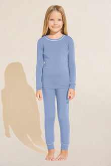 Model wears Kids TENCEL Modal Unisex Long PJ Set in Wedgewood Blue/Ivory.