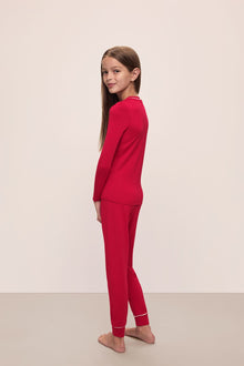 Model wears Kids TENCEL Modal Unisex Long PJ Set in Haute Red/Ivory.
