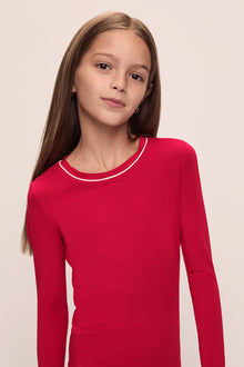 Model wears Kids TENCEL Modal Unisex Long PJ Set in Haute Red/Ivory.