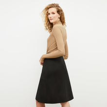 Front image of a woman standing wearing the axam top in camel