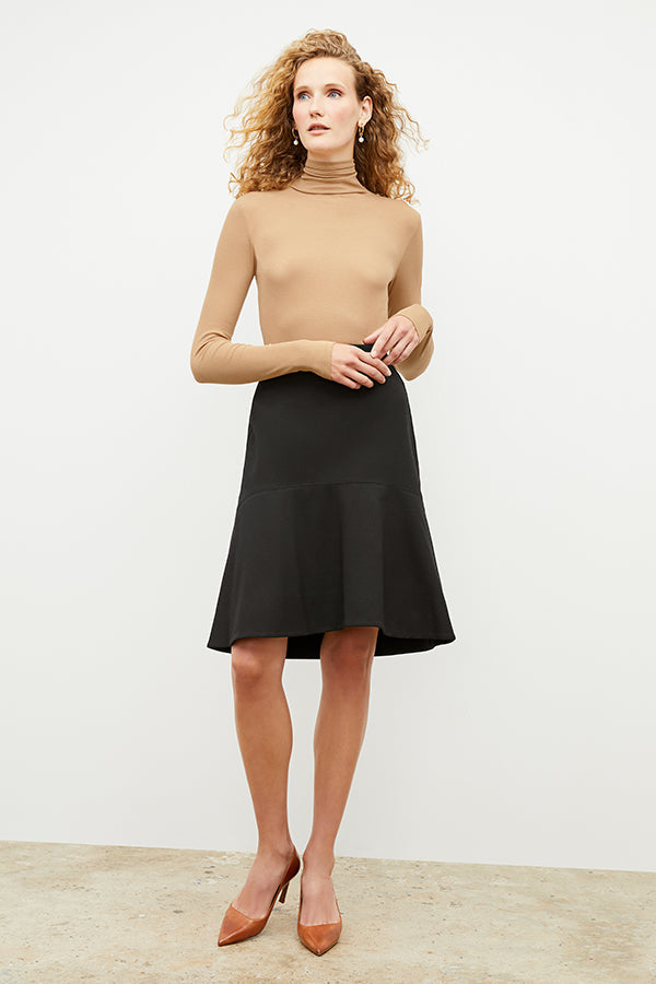 Front image of a woman standing wearing the axam top in camel | Exclude
