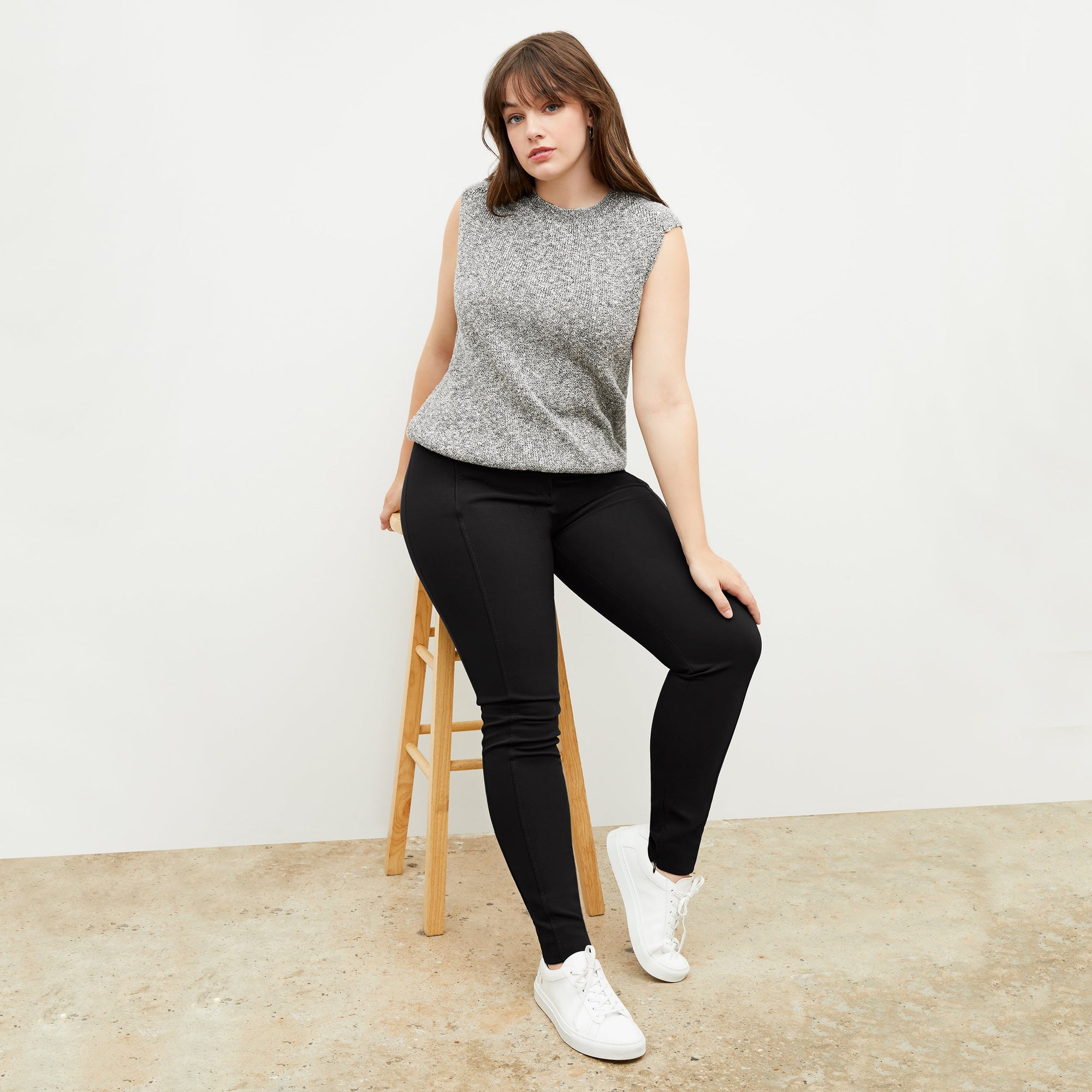 Front image of a woman standing wearing the curie pant in black