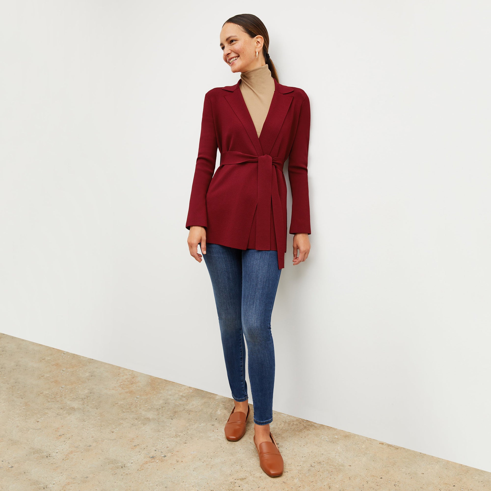 Front image of a woman standing wearing the axam top in camel | Exclude