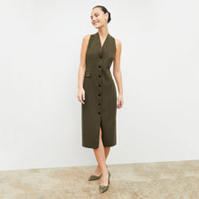Front image of a woman wearing the Cassandra dress in origamitech in olive | Lead