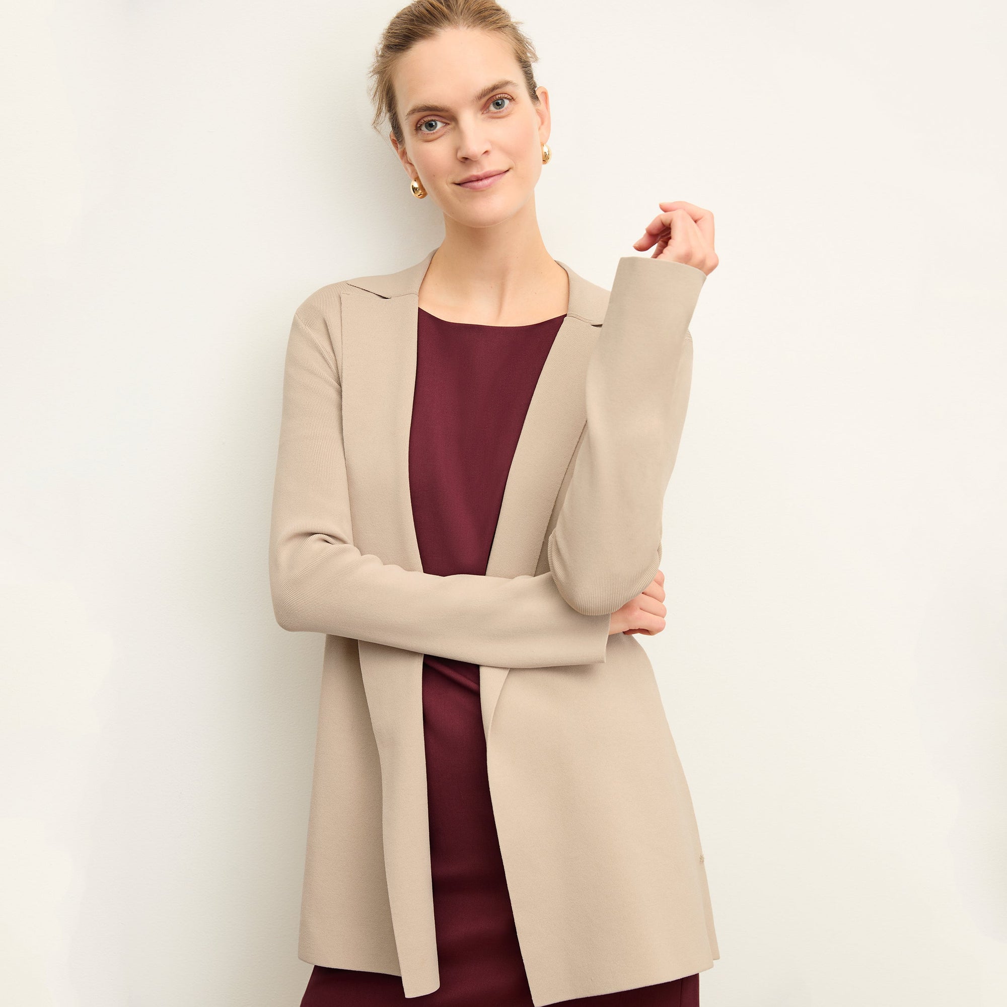 Front image of a woman standing wearing the Merritt jardigan in latte | Exclude