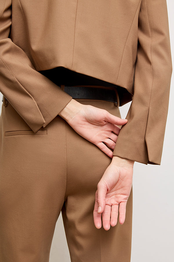 back image of a woman standing wearing the Neale jacket in camel | Exclude | Grid Hover