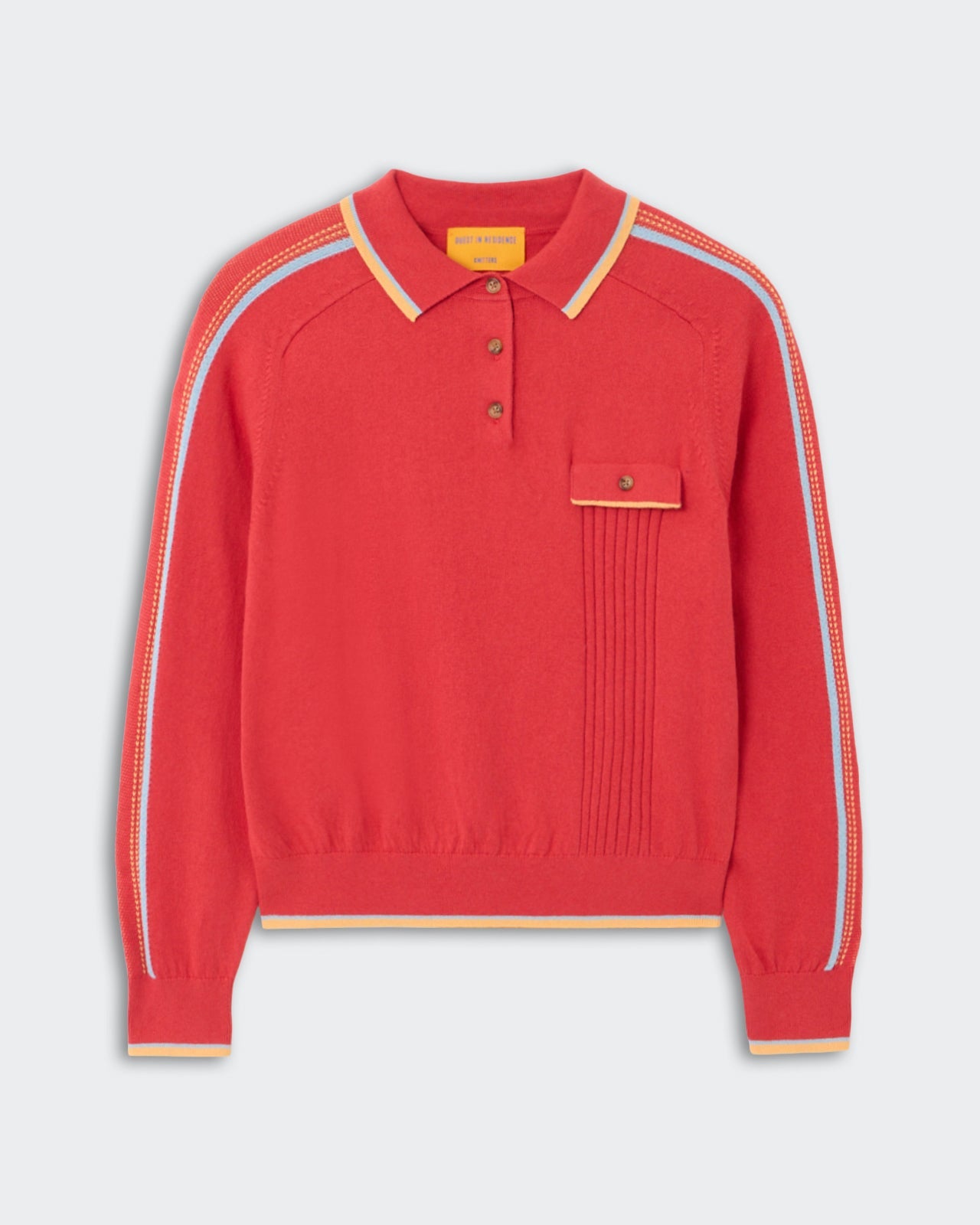 Relay Polo - Scarlet, a vibrant red knit long-sleeve polo featuring a buttoned chest pocket with pleated detailing, contrasting yellow and blue stripes along the shoulders and sleeves, and ribbed cuffs and hem.