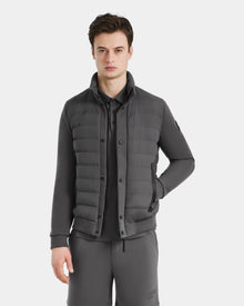 A young man wearing the RAGAB - 6124577 Grey hybrid jacket by Rudsak over a matching zip-up top and pants stands against a white background, one hand in his pocket—a modern look ideal for transitional weather.