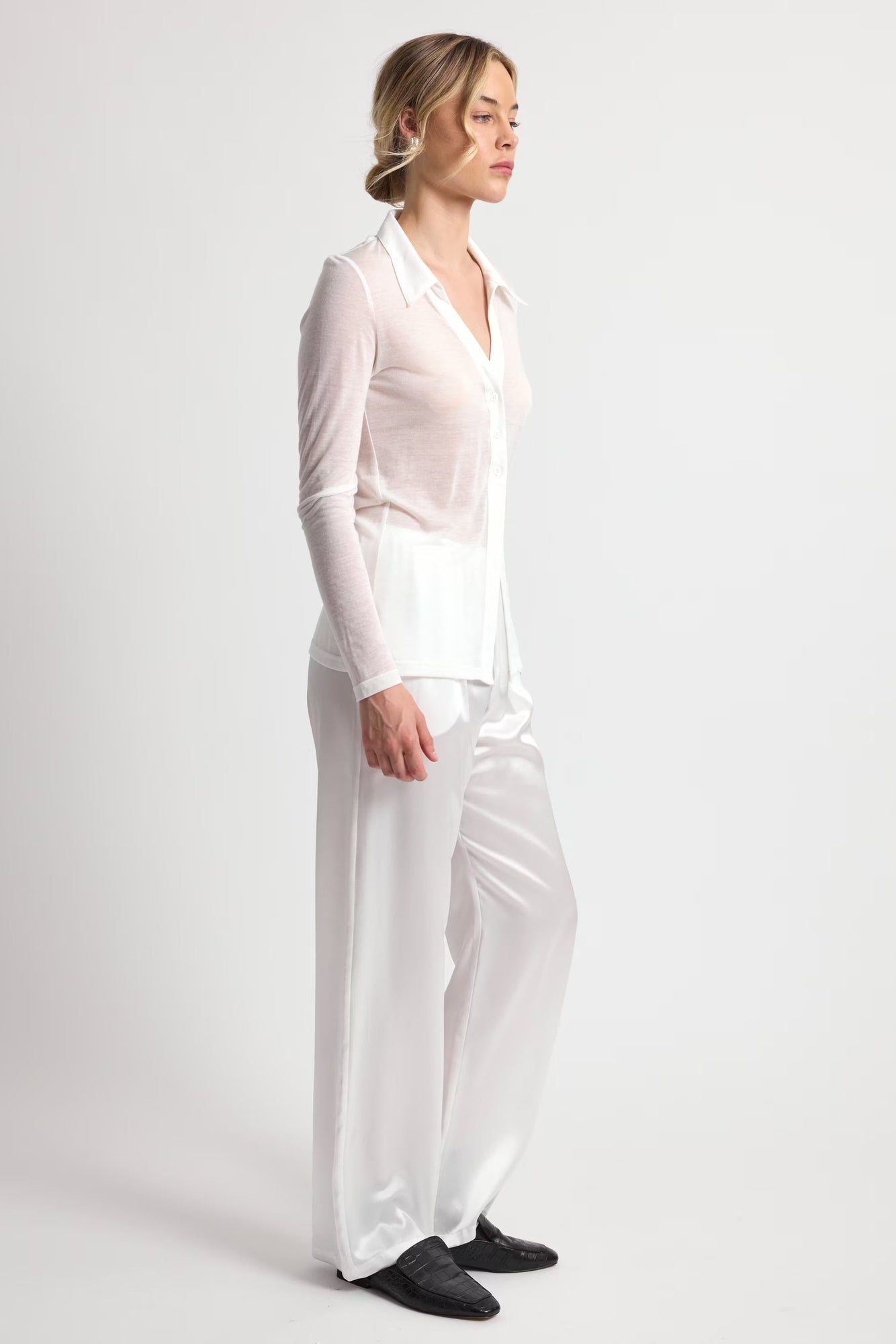 Woman wearing a white outfit on a plain background