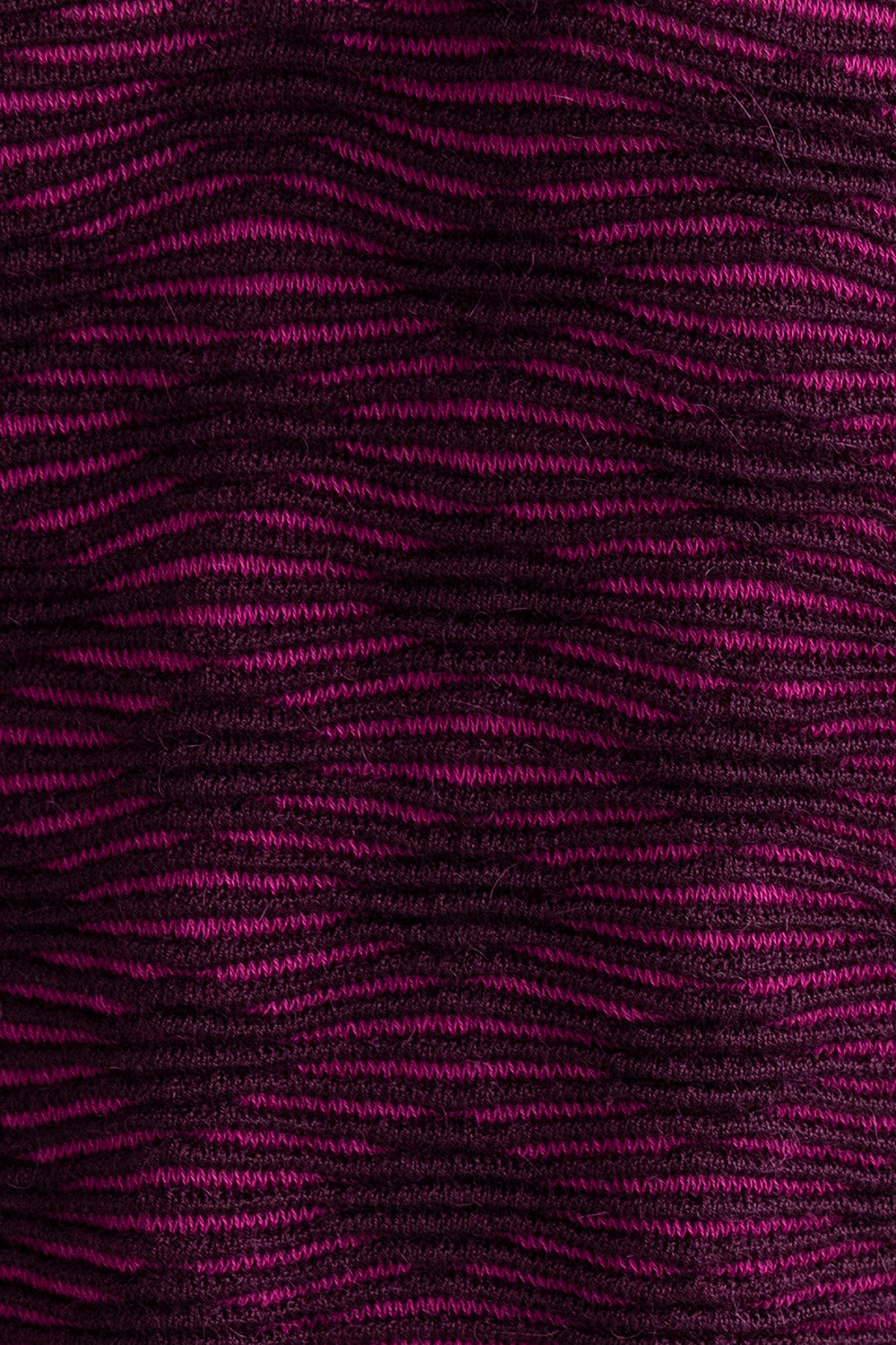 Detail shot of the Amelie Polo showcasing the monochromatic textured pattern in fuchsia and aubergine. Ethically made from baby alpaca and cotton.
