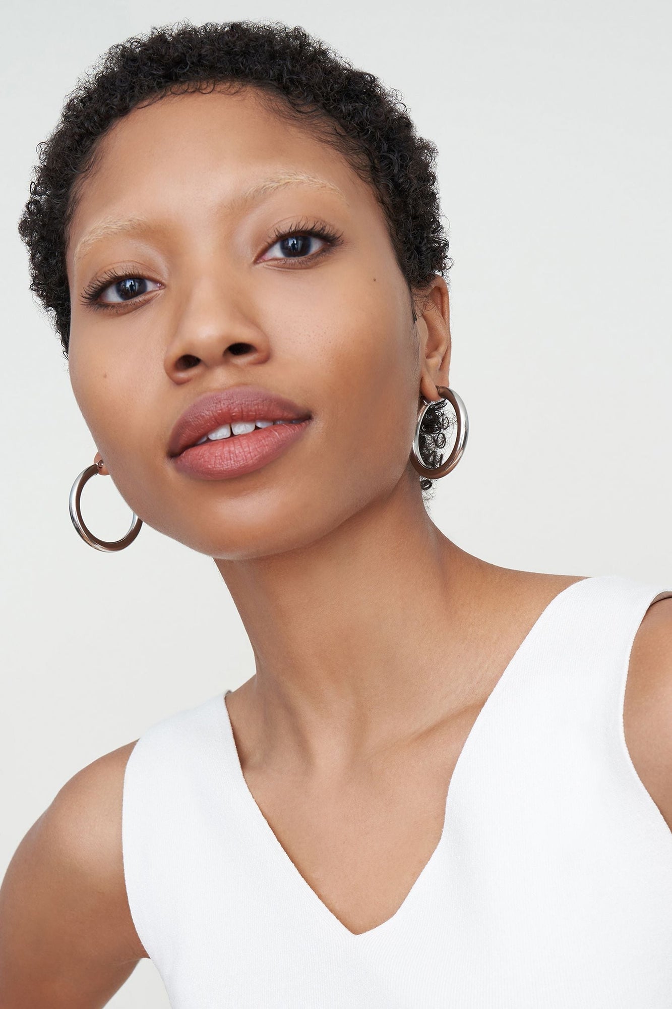 Detail image of a woman standing wearing the Claressa Earrrings Medium in Silver | Exclude