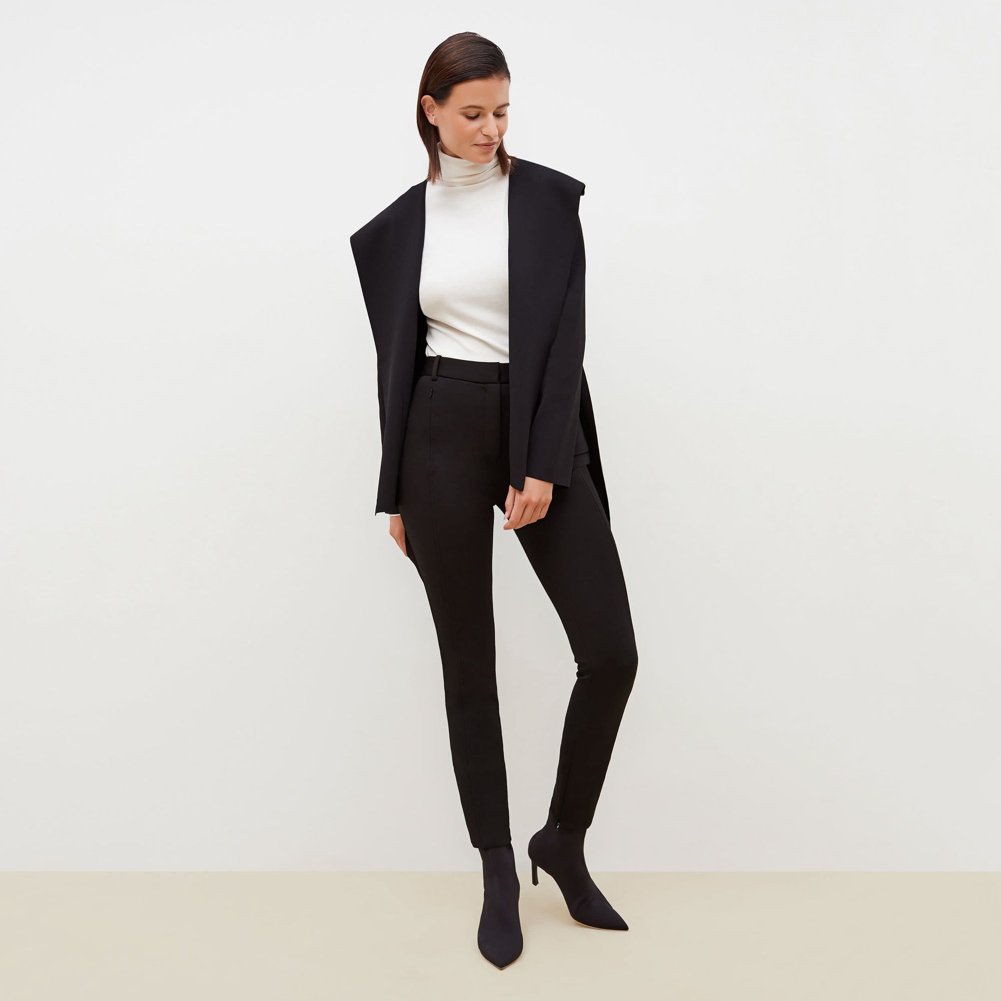 Front image of a woman standing wearing the Curie Pant--Worth in Black | Exclude