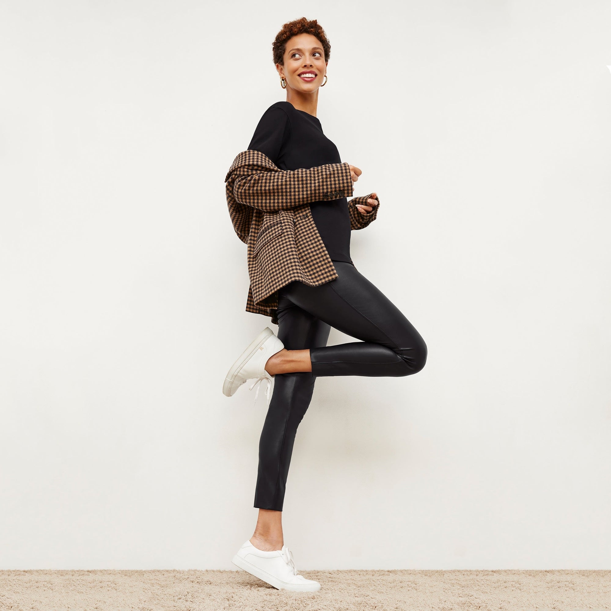 Side image of a woman standing wearing the Harrington Leather—Vegan Leather in Black