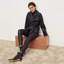 Side image of a woman standing wearing the Harrington Leather—Vegan Leather in Black