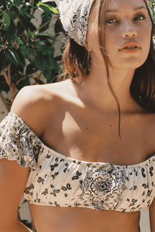 White bandana bikini top with black paisley and floral print, off-shoulder ruffle design.